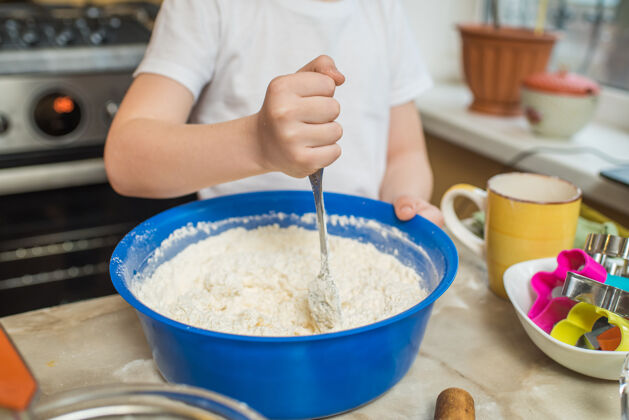 童年一个在家里搅拌面团的孩子的手房子烹饪厨房