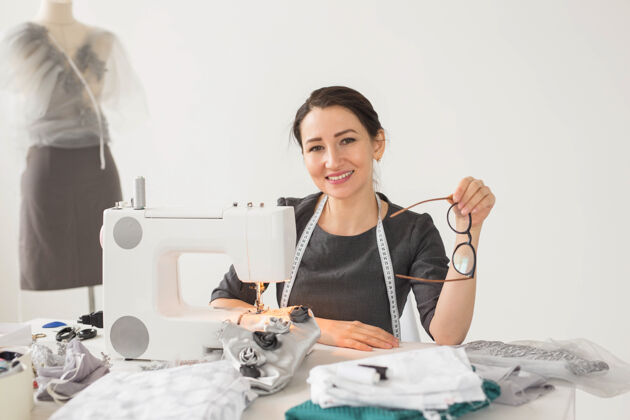材料裁缝 裁缝和创意概念-服装设计师的肖像与缝纫机在白色表面设计师生产服装