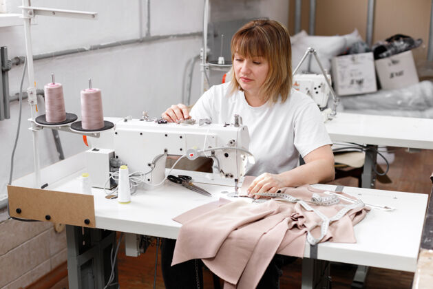 裁缝在缝纫机后面工作的女人工艺设计师设备