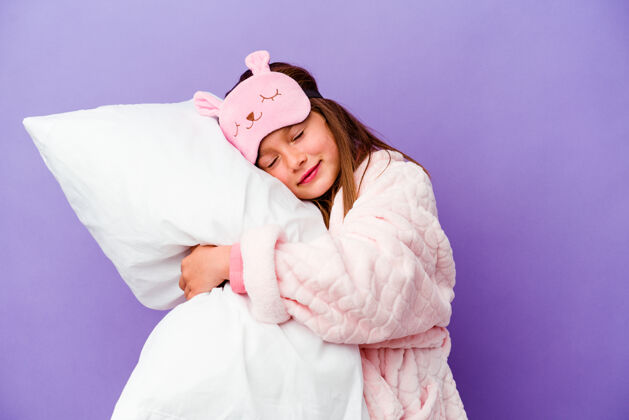 坐垫小女孩抱着一个枕头快乐地孤立在紫色上拥抱休闲睡觉时间
