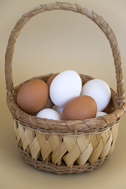 杂货白色和棕色的鸡蛋放在淡褐色的柳条篮子里饮食农场混合