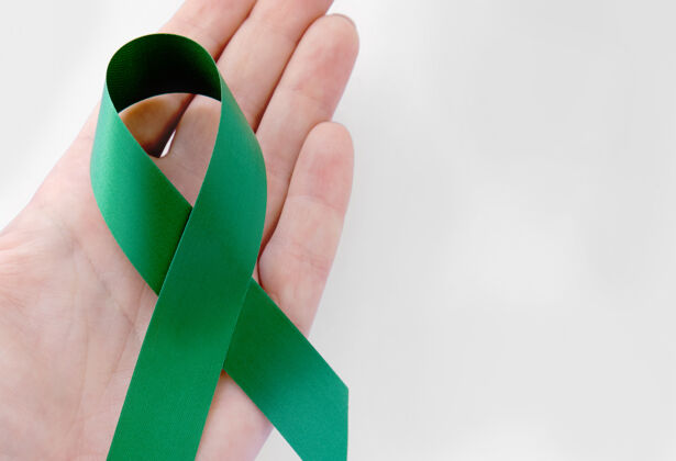 护理手上的绿色象征性丝带人体器官健康年龄