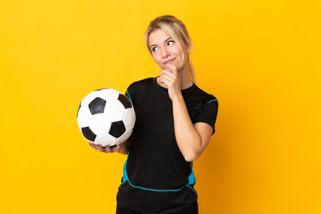 专业年轻的俄罗斯足球运动员 一个被隔离在黄色背景下仰望的女人年轻比赛思维