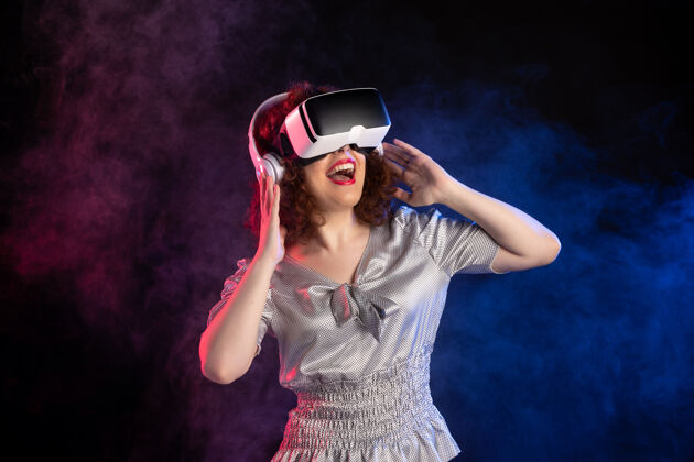 虚拟现实年轻女性戴着vr耳机在黑暗的游戏视频播放耳机游戏耳机游戏