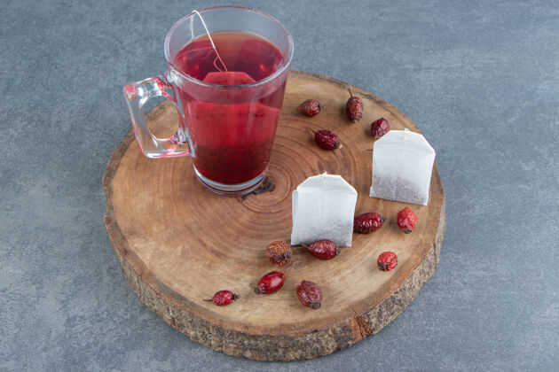 红色一杯装在木片上的玫瑰果茶抗氧化剂玻璃水果