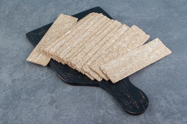 食物一块黑色的木板 上面放满了酥脆的格雷厄姆面包营养小麦脆