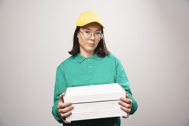 模型送货员拿着一张白色的高质量的比萨饼卡片美味眼镜帽子