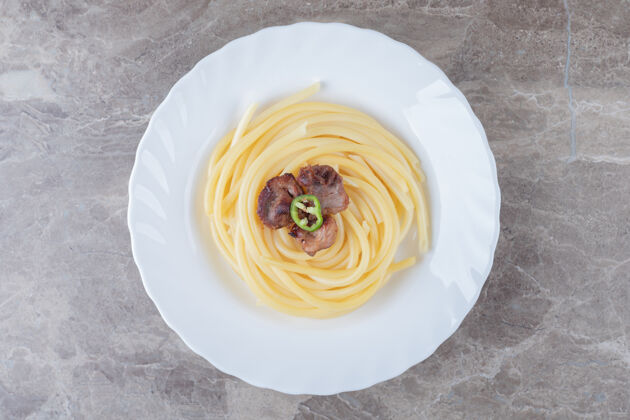 美味把烤好的肉放在意大利面上 放在盘子里 放在大理石的表面上蛋白质意大利面美味