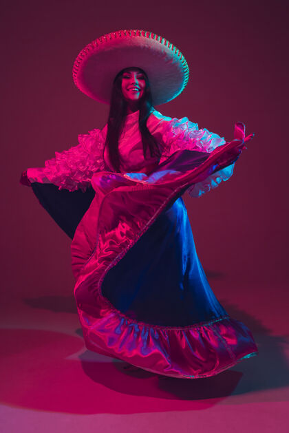 衣服美丽的cincodemayo女舞者在霓虹灯下的紫色墙上跳舞战斗霓虹灯娱乐