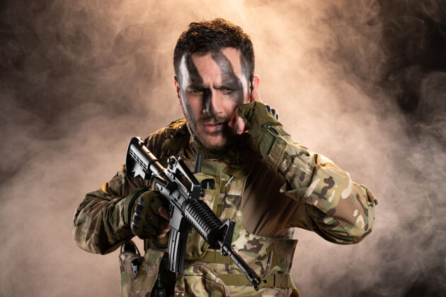 军人黑烟墙上 一名身穿迷彩服 手持机枪的男战士战士人肖像