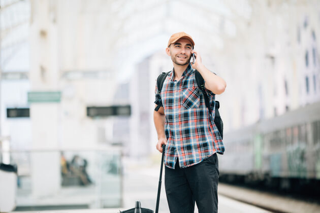 手机年轻的旅行者在火车站打电话胡须小时时间