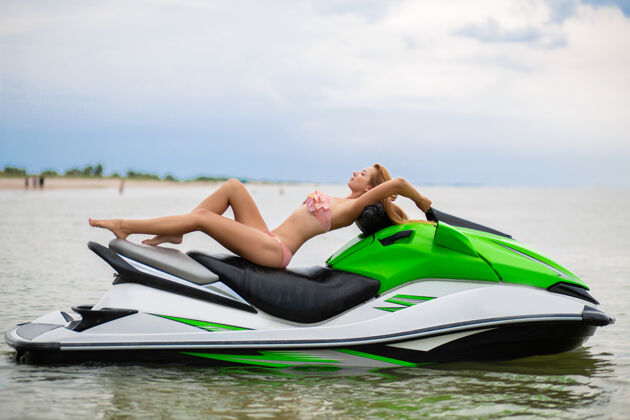 滑板车穿着时尚比基尼泳装 身材苗条的年轻迷人女子 在水上摩托上享受乐趣 暑假 积极运动泳装身体海洋