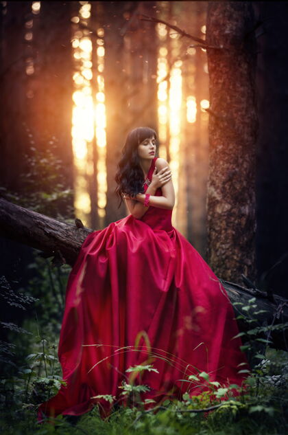 神秘一个穿着红色长裙的女人独自在房间里森林太棒了晚上 一个神秘的女孩出现在黑暗的森林里太阳日落在森林里魅力女性女人