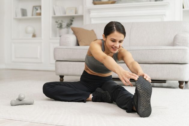 运动装穿着运动服在家锻炼的女人房子训练健身