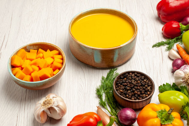 西红柿前视图美味的南瓜汤奶油蔬菜纹理与白色桌子上成熟的汤酱一餐桌子午餐蔬菜