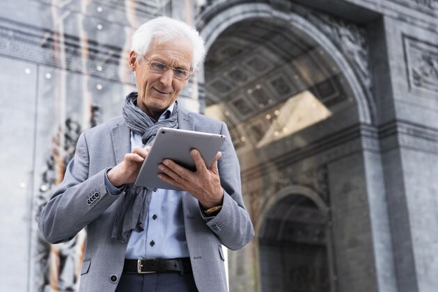 老年人时尚的老男人在城市里使用平板电脑成熟水平老