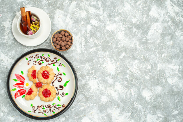 饼干顶视图美味饼干与红色果冻内板上的白色背景糖饼干蛋糕饼干甜茶顶部西红柿餐厅