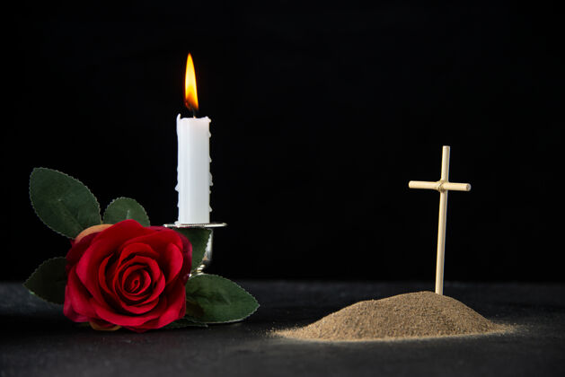 夜晚带蜡烛和玫瑰的黑色小坟墓的正面图玫瑰蜡烛黑暗
