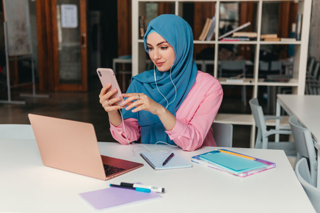 工作年轻漂亮的现代妇女戴着头巾在办公室的笔记本电脑上工作 教育在线教育文化移动