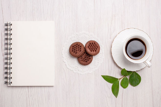 饼干顶视图一杯茶 白色桌面上有巧克力饼干糖茶饼干甜饼干茶杯糖咖啡