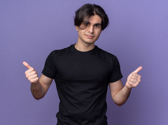 感觉高兴的年轻帅哥穿着黑色t恤 竖起大拇指孤立地站在紫色的墙上帅气人脸