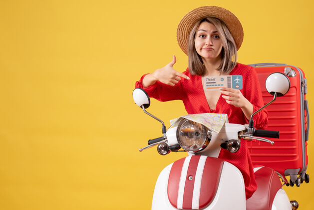 旅行者前视图穿着红色衣服的年轻女士指着轻便摩托车上的车票成人滑板车度假