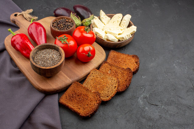 盘子前视图新鲜西红柿与黑面包面包和白奶酪在黑暗的空间香料晚餐午餐