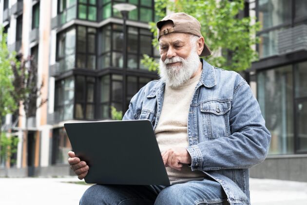 老年人在城市户外使用笔记本电脑的老人老年人退休老年人