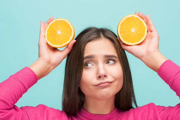 营养美丽的女人的脸与美味的橙色在工作室柑橘女孩健康