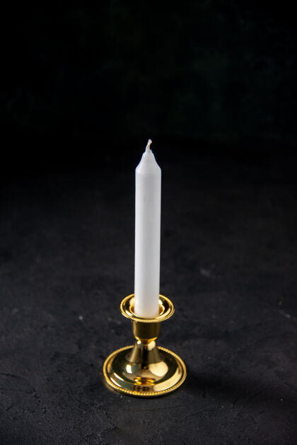 死亡在黑色的金色的立场上白色蜡烛的正面视图黑暗烛台纪念