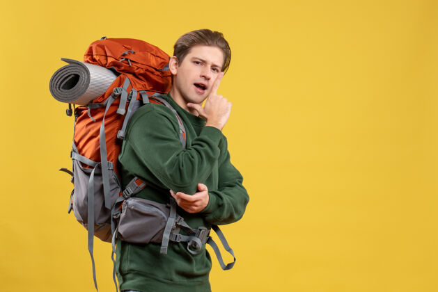 成人正面图年轻男子背着背包准备远足黄色自然人