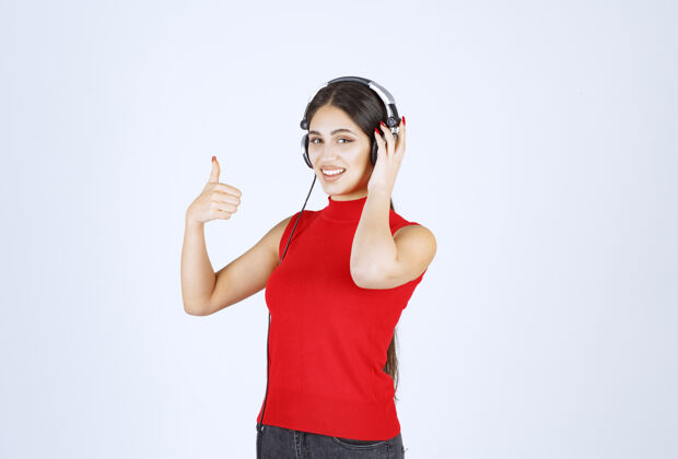 员工穿着红衬衫的Dj戴着耳机欣赏音乐服装姿势年轻
