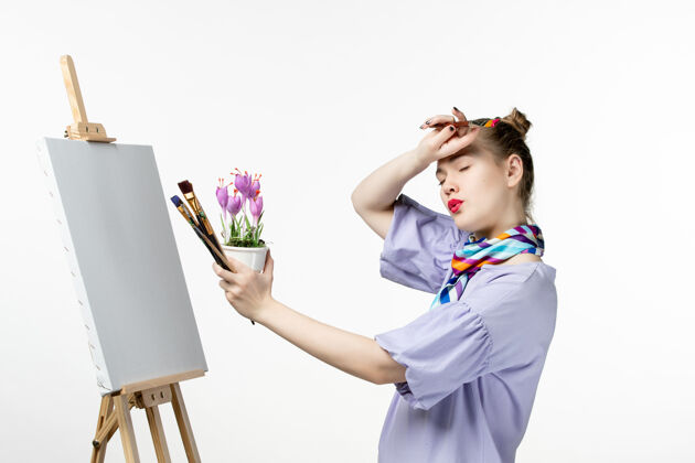 画架前视图女画家在白墙上画花的照片艺术家画架艺术画颜料微笑肖像正面