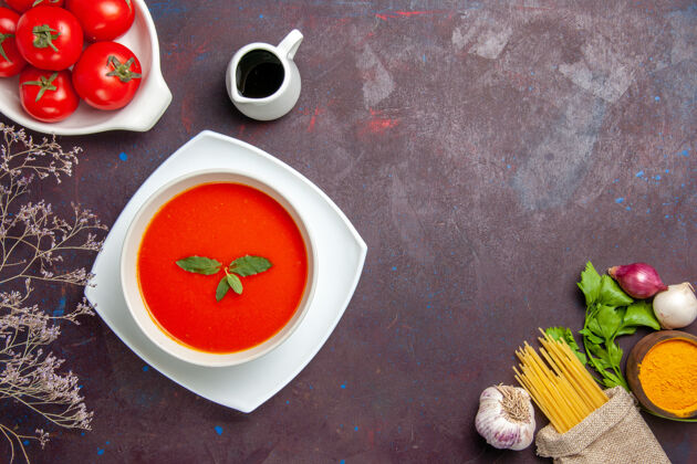 新鲜俯瞰美味的西红柿汤配上新鲜的西红柿放在深色的桌子上 酱汁西红柿色的一餐汤盘子容器食物