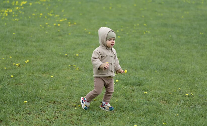 外面可爱的孩子在草地上散步小蹒跚学步家庭