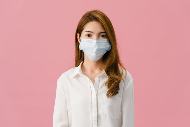 流感年轻的亚洲女孩戴着医用面罩 穿着休闲服 看着隔离在粉色背景下的相机社会严重护理