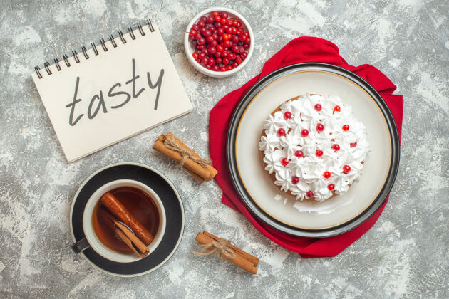 奶油蛋糕红布上点缀着水果的奶油蛋糕俯视图肉桂酸橙茶