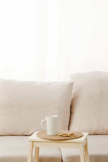 茶灯光下米色沙发附近一张小桌子上放着一个杯子的垂直照片房子放松室内