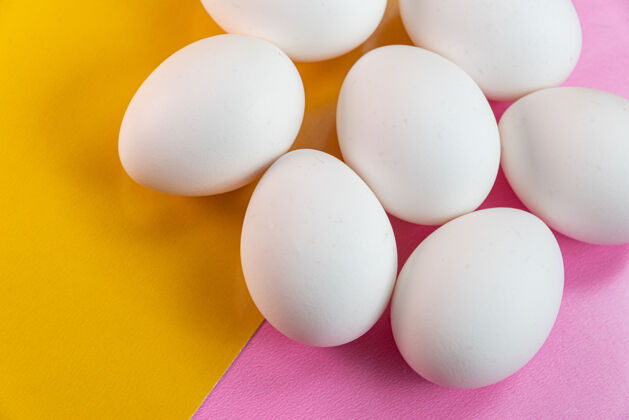 鸡蛋黄色和粉色桌子上的鸡蛋美食家生的健康食品