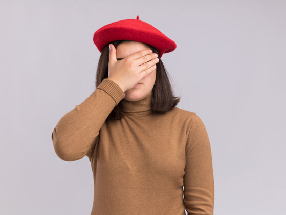 贝雷帽失望的年轻漂亮白人女孩戴着贝雷帽把手放在脸上年轻失望帽子