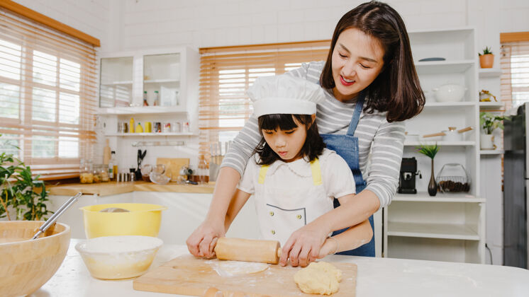 饼干快乐微笑的日本亚裔小家庭 带着学龄前的孩子 享受烹饪烘焙糕点的乐趣面包房孩子女儿