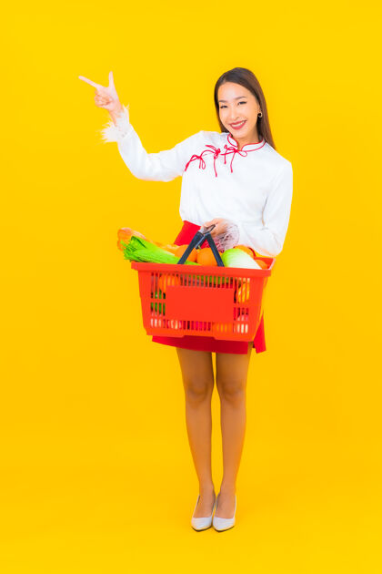 室内一幅美丽的亚洲年轻女子的画像 黄色的是超市里的购物篮篮子购物杂货店
