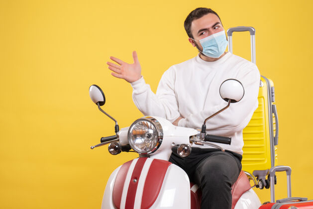 球员旅行的概念和困惑的家伙在医疗面具坐在摩托车上 黄色的手提箱在它的黄色面具人高尔夫球手