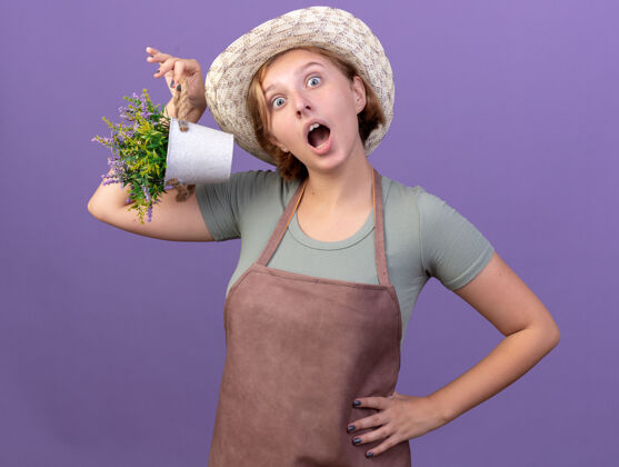 花震惊了年轻的斯拉夫女园丁戴着园艺帽拿着花盆里的花女性帽子园艺