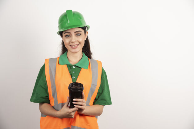 开发带着黑色杯子微笑的女建造师高质量照片专家安全帽茶