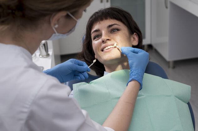 工人年轻的女病人在正畸医生那里做牙科手术专业牙科工作妇女