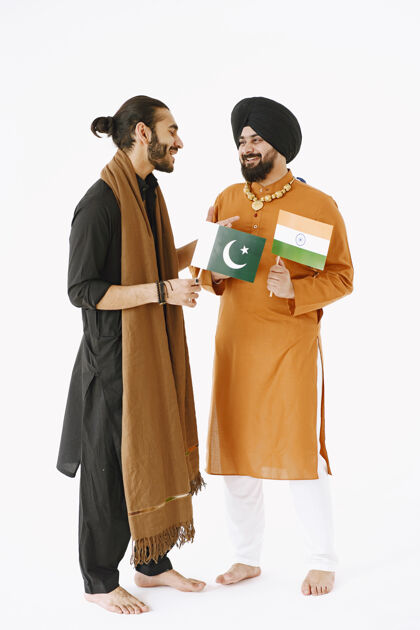 亚洲穿着传统服装的巴基斯坦男人和印度男人朋友们在白色背景下交谈 与世隔绝国家间的友好印度男人文化