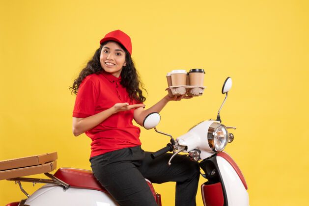 女信使前视图骑自行车的女快递员拿着咖啡杯在黄色背景上工作服工作服女快递员工作工作送货制服