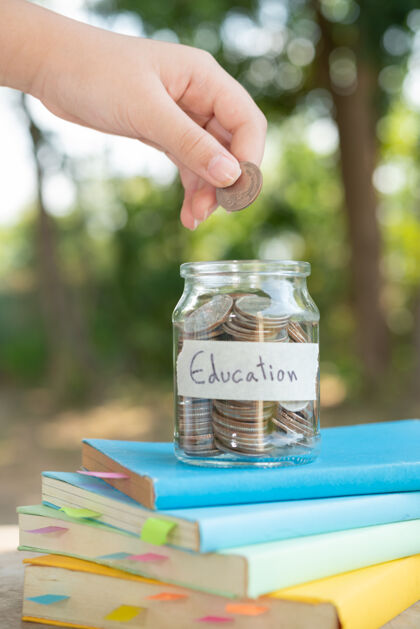 大学把存钱的硬币放在玻璃瓶中 用于概念投资 共同基金 金融和商业 放在教科书上内容：教育存钱金融增长存款