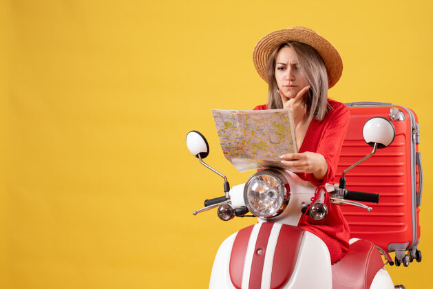 坐着骑着轻便摩托车 带着红色手提箱的漂亮女孩在看地图封面女郎时尚红色